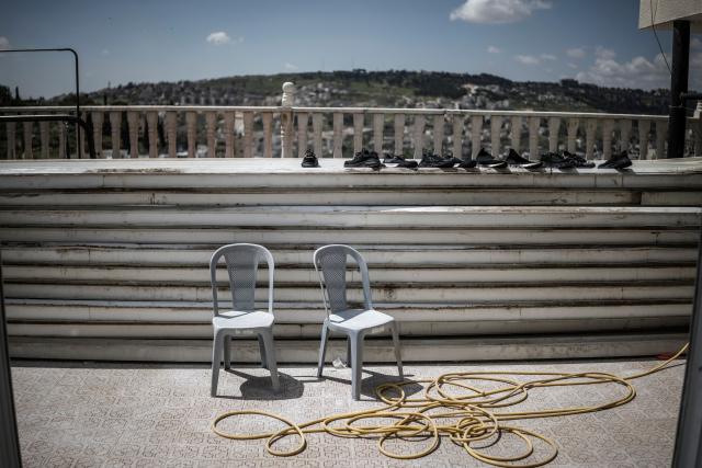 A row of shoes is left to dry on the terrace of Mahmoud al-Tawil's roofless apartment on the top floor of his family home in the Shayah district of Ras al-Amud in east Jerusalem, on April 12, 2026. The rooftop of the al-Tawil family home has been slated for voluntary demolition with an injunction from the Jerusalem Municipality for lack of proper building permits.
Israeli authorities regularly target what they describe as unauthorised construction in Jerusalem's annexed east, a campaign that local Palestinian officials characterise as a "systematic policy" to displace residents. (Photo by MARCO LONGARI / AFP)