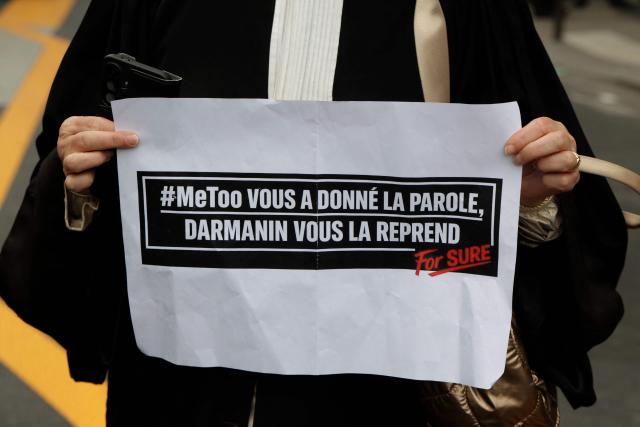 A lawyer holds placard reading "MeToo gave you a voice, Darmanin is taking it away" during a demonstration against the "SURE" (Useful, Fast and Effective Sentencing) draft bill, in particular its proposal to introduce plea bargaining in criminal matters, as the French Senate begins debating the text, in Paris on April 13, 2026. Lawyers across France staged a nationwide "Justice morte" (Dead Justice) stoppage called by most of the country's 164 bar associations, as the Senate opened debate on the bill which the government says is needed to tackle a backlog of more than 6,000 pending criminal cases. (Photo by Ludovic MARIN / AFP)