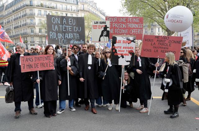 Lawyers take part in a demonstration against the "SURE" (Useful, Fast and Effective Sentencing) draft bill, in particular its proposal to introduce plea bargaining in criminal matters, as the French Senate begins debating the text, in Paris on April 13, 2026. Lawyers across France staged a nationwide "Justice morte" (Dead Justice) stoppage called by most of the country's 164 bar associations, as the Senate opened debate on the bill which the government says is needed to tackle a backlog of more than 6,000 pending criminal cases. (Photo by Ludovic MARIN / AFP)