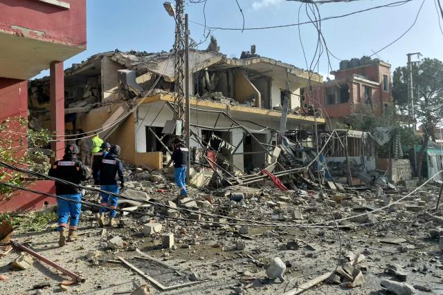 First responders gather at the site of an Israeli airstrike that targeted a neighbourhood in the southern Lebanese village of Kfar Roummane, on April 13, 2026. Lebanon was pulled into the Middle East war when Hezbollah fired rockets at Israel after US-Israeli strikes killed Iran's supreme leader on February 28. Israel responded with massive strikes and a ground invasion. (Photo by Abbas Fakih / AFP) / 
