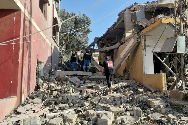 First responders gather at the site of an Israeli airstrike that targeted a neighbourhood in the southern Lebanese village of Kfar Roummane, on April 13, 2026. Lebanon was pulled into the Middle East war when Hezbollah fired rockets at Israel after US-Israeli strikes killed Iran's supreme leader on February 28. Israel responded with massive strikes and a ground invasion. (Photo by Abbas Fakih / AFP) / 