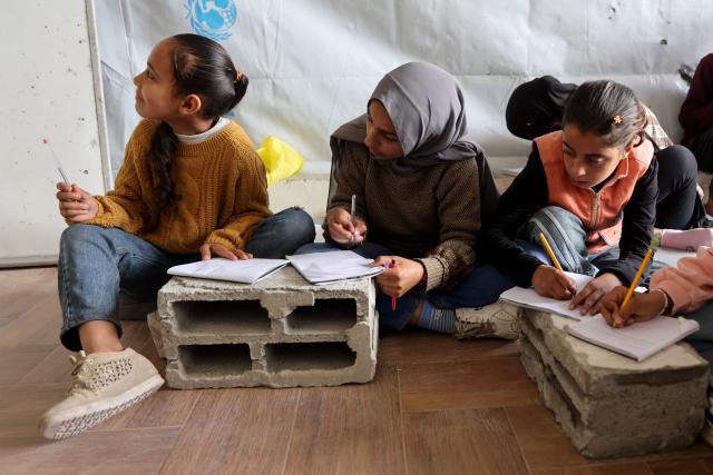 Displaced Palestinian children attend class inside a tent at the Mada Educational School in the Jabalia refugee camp in the northern Gaza Strip on April 13, 2026. Since the terms of a US-brokered ceasefire deal came into effect on October 10, Israel remains in control of nearly half of the Gaza Strip, including all its border areas. Nearly two million people in Gaza are living in makeshift shelters, and the humanitarian situation remains dire, according to aid agencies. (Photo by Omar AL-QATTAA / AFP)