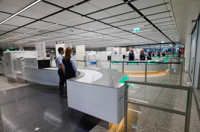 Airport personnel stand at the security check area of the new Terminal 1 pier during its official opening at Munich International Airport in Munich, southern Germany on April 13, 2026. The Terminal 1 Pier provides additional capacity for up to six million passengers per year. The new building is currently one of Bavaria’s largest infrastructure projects. (Photo by ALEXANDRA BEIER / AFP)