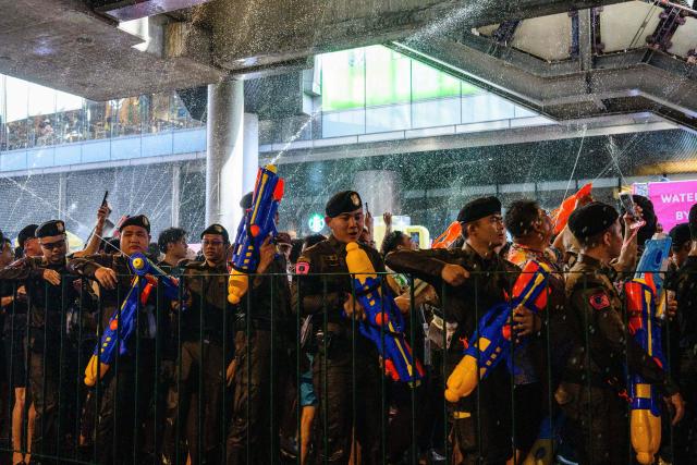 Police and revellers take part in mass water fights on the first day of Songkran, or Thai New Year, in Bangkok on April 13, 2026. (Photo by Anthony WALLACE / AFP)