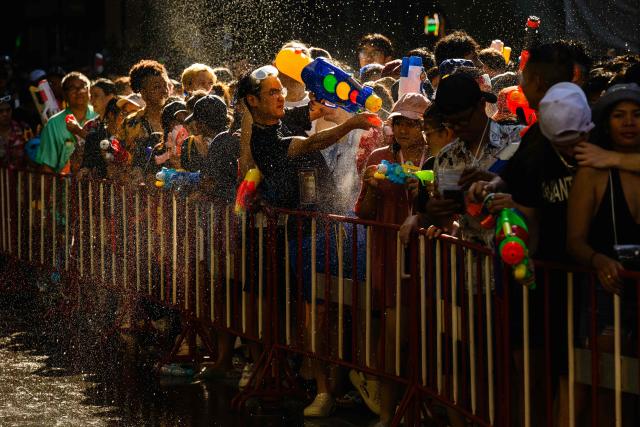 Revellers take part in mass water fights on the first day of Songkran, or Thai New Year, in Bangkok on April 13, 2026. (Photo by Anthony WALLACE / AFP)