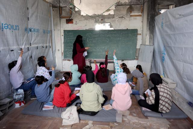 Displaced Palestinian children attend class inside a tent at the Mada Educational School in the Jabalia refugee camp in the northern Gaza Strip on April 13, 2026. Since the terms of a US-brokered ceasefire deal came into effect on October 10, Israel remains in control of nearly half of the Gaza Strip, including all its border areas. Nearly two million people in Gaza are living in makeshift shelters, and the humanitarian situation remains dire, according to aid agencies. (Photo by Omar AL-QATTAA / AFP)