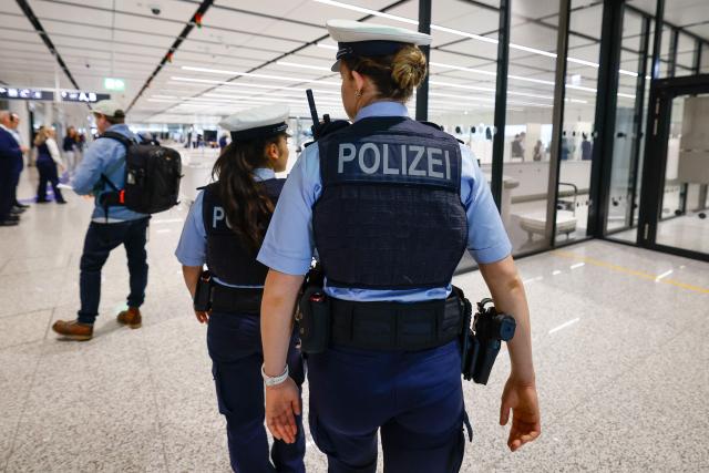 Two German police officers patrol at the security check area of the new Terminal 1 pier at Munich International Airport during the official opening in Munich on April 13, 2026. The Terminal 1 Pier provides additional capacity for up to six million passengers per year. The new building is currently one of Bavaria’s largest infrastructure projects. (Photo by ALEXANDRA BEIER / AFP)