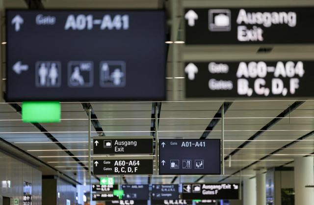 This photo taken on April 13, 2026 shows signs indicating the exit and gates at the new Terminal 1 pier at Munich International Airport during the official opening in Munich, southern Germany. The Terminal 1 Pier, which will begin operations on April 21, 2026, provides additional capacity for up to six million passengers per year. The new building is currently one of Bavaria’s largest infrastructure projects. (Photo by ALEXANDRA BEIER / AFP)