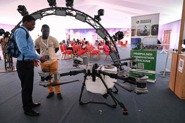 A visitor looks at a drone during the 2nd edition of the International Exhibition on Artificial Intelligence, Defence and Space in Abidjan on April 13, 2026. (Photo by Issouf SANOGO / AFP)