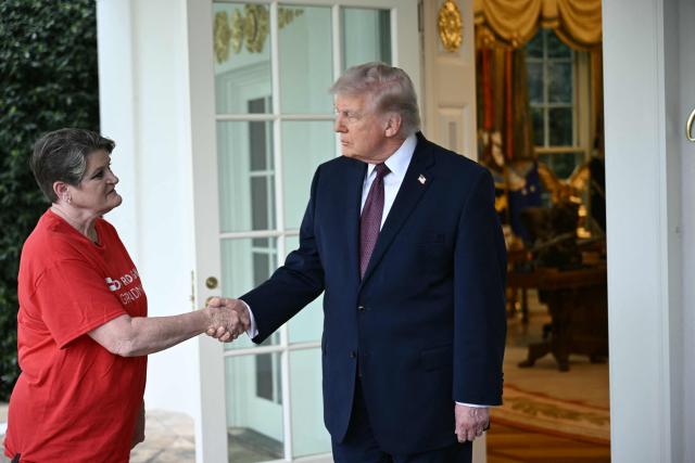 US President Donald Trump shakes hands with a Doordash delivery worker  after she delivered Mcdonalds at the Oval Office at the White House, in Washington, DC, April 13, 2026. (Photo by Brendan SMIALOWSKI / AFP)