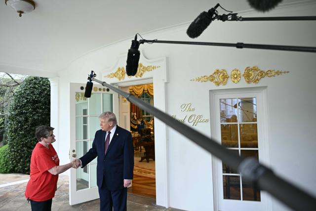 US President Donald Trump shakes hands with a Doordash delivery worker  after she delivered Mcdonalds at the Oval Office at the White House, in Washington, DC, April 13, 2026. (Photo by Brendan SMIALOWSKI / AFP)