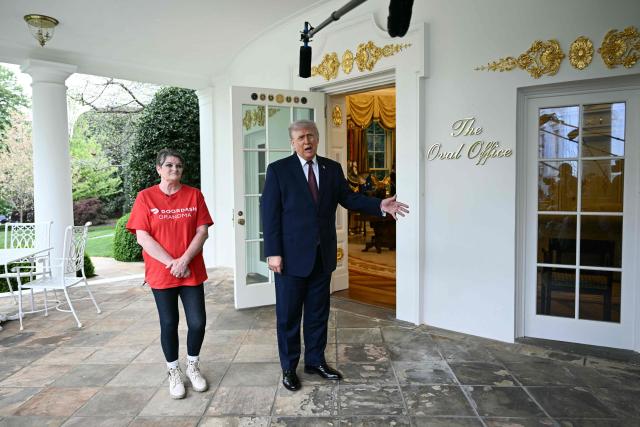 US President Donald Trump speaks to reporters next to a Doordash delivery worker Sharon Simmons after she delivered Mcdonald's outside of the Oval Office at the White House, in Washington, DC, April 13, 2026. (Photo by Brendan SMIALOWSKI / AFP)