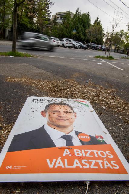 An election campaign poster of a candidate for the Fidesz party lies on the side of a road in Budapest, Hungary on April 13, 2026, one day after general elections. Hungarian prime minister-elect Peter Magyar pledged on April 13 to usher in a "new era" after defeating nationalist leader Viktor Orban in elections seen as a blow to hard-right populism. (Photo by Ferenc ISZA / AFP)