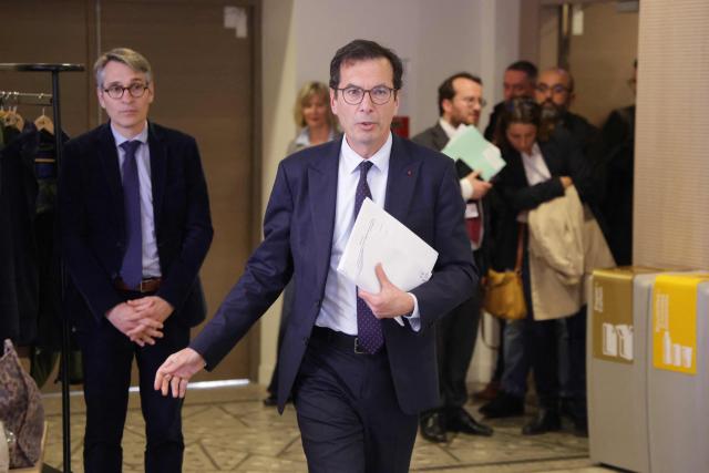 France's Labour Minister Jean-Pierre Farandou (C) leaves following a meeting with unions to discuss the proposed May 1st bill, in Paris on April 13, 2026. (Photo by Ludovic MARIN / AFP)