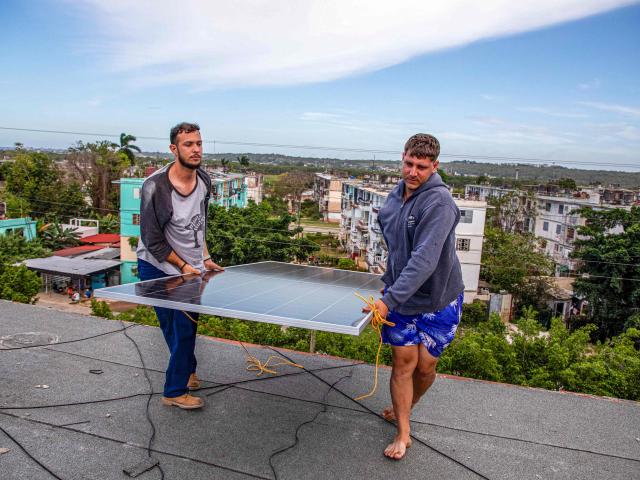 Solar panel specialists install solar panels on the rooftop of a multi-family building in Matanzas, Cuba, on April 13, 2026. (Photo by AFP)