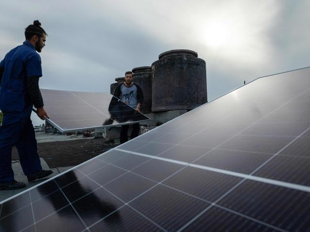 Solar panel specialists install solar panels on the rooftop of a multi-family building in Matanzas, Cuba, on April 13, 2026. (Photo by AFP)