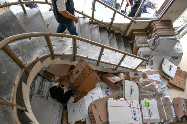 Election officials of Peru's National Office of Electoral Processes (ONPE) inspect electoral materials for registration and storage during the second day of the presidential election in Pucallpa, Peru on April 13, 2026. Two Peruvian right-wing candidates looked set on April 13, 2026, to advance to a presidential runoff, after an election marred by logistical foul-ups and deep voter anger. Voting is still underway at around a dozen polling places in Lima, where ballot materials failed to arrive on time for April 12 election. (Photo by Hugo Alejos / AFP)