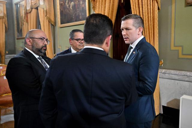 US Assistant Secretary of Energy Kyle Haustveit (R) talks with President of Chevron Venezuela, Mariano Vela (C-R), and Chevron Venezuela executives during a signing of an agreement ceremony between Chevron Venezuela and the national government at the Miraflores Palace in Caracas on April 13, 2026. (Photo by Juan BARRETO / AFP)