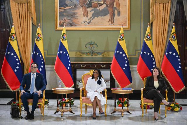 Venezuela's interim President Delcy Rodriguez (C) looks on next to Sectoral Vice President for Economy and Finance Calixto Ortega (L) and Minister of Petroleum and Hydrocarbons Paula Henao during a press conference after a signing of an agreement ceremony between Chevron Venezuela and the national government at the Miraflores Palace in Caracas on April 13, 2026. Venezuelas interim president, Delcy Rodriguez, praised on April 13 the progress made in the oil sector regarding foreign investment as part of the signing of agreements with the U.S. giant Chevron to increase crude oil production. (Photo by Juan BARRETO / AFP)