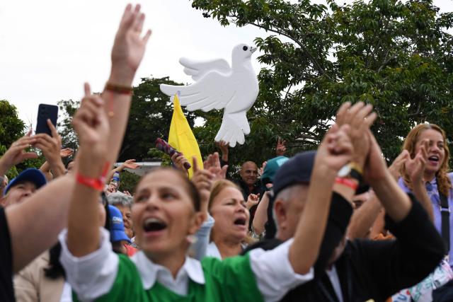 A supporter of Colombia's presidential candidate Paloma Valencia holds a dove-shaped cutout during a campaign rally in Rionegro, Antioquia department, Colombia, on April 13, 2026. The Colombian government reinforced security for opposition presidential candidate Paloma Valencia after she reported receiving death threats less than two months before the election. Colombia will hold presidential elections on May 31. (Photo by Jaime SALDARRIAGA / AFP)