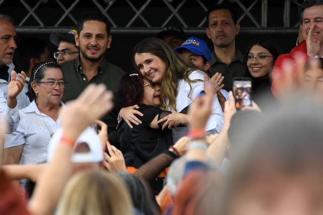 Colombia's presidential candidate Paloma Valencia (C, right), of the Centro Democratico party, embraces a supporter during a campaign rally in Rionegro, Antioquia department, Colombia, on April 13, 2026. The Colombian government reinforced security for opposition presidential candidate Paloma Valencia after she reported receiving death threats less than two months before the election. Colombia will hold presidential elections on May 31. (Photo by Jaime SALDARRIAGA / AFP)
