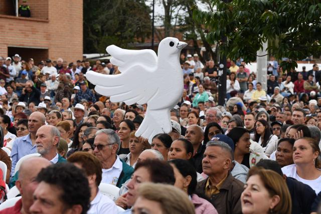 A supporter of Colombia's presidential candidate Paloma Valencia holds a dove-shaped cutout during a campaign rally in Rionegro, Antioquia department, Colombia, on April 13, 2026. The Colombian government reinforced security for opposition presidential candidate Paloma Valencia after she reported receiving death threats less than two months before the election. Colombia will hold presidential elections on May 31. (Photo by Jaime SALDARRIAGA / AFP)