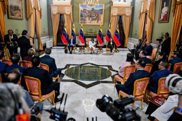 Venezuela's interim President Delcy Rodriguez (C) looks on next to Sectoral Vice President for Economy and Finance Calixto Ortega (L) and Minister of Petroleum and Hydrocarbons Paula Henao during a press conference after a signing of an agreement ceremony between Chevron Venezuela and the national government at the Miraflores Palace in Caracas on April 13, 2026. Venezuelas interim president, Delcy Rodriguez, praised on April 13 the progress made in the oil sector regarding foreign investment as part of the signing of agreements with the U.S. giant Chevron to increase crude oil production. (Photo by Juan BARRETO / AFP)