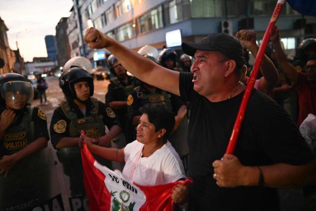 People protest outside the offices of the National Office of Electoral Processes (ONPE) in Lima on April 13, 2026. Two Peruvian right-wing candidates looked set on April 13, 2026, to advance to a presidential runoff, after an election marred by logistical foul-ups and deep voter anger. Voting is still underway at around a dozen polling places in Lima, where ballot materials failed to arrive on time for April 12 election. (Photo by ERNESTO BENAVIDES / AFP)