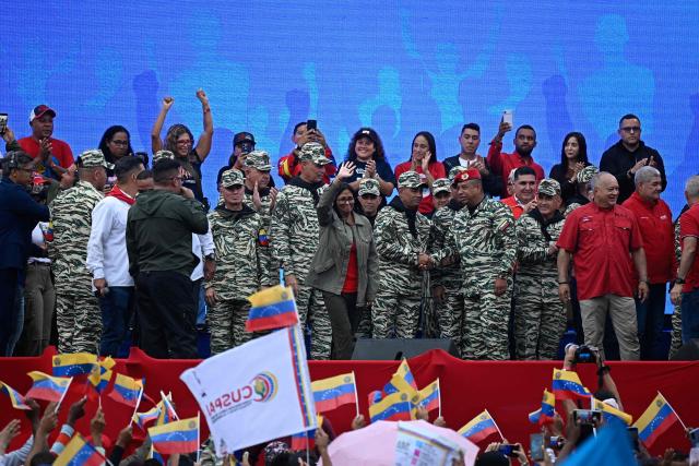 Venezuela's interim President Delcy Rodriguez (C) waves during a civil-military parade marking the 24th anniversary of late Venezuelan president Hugo Chavez's (1999-2013) return to power after a failed 2002 coup, in Caracas on April 13, 2026. (Photo by Federico PARRA / AFP)