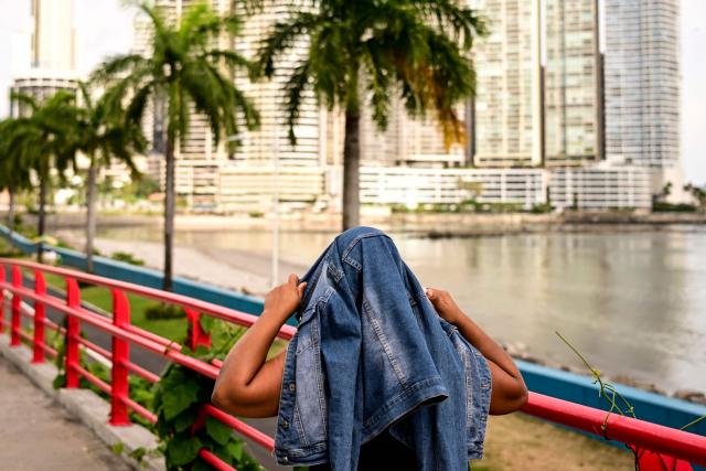 A woman shields herself from the sun amid high temperatures in Panama City on April 13, 2026. Alerts for intense solar radiation and extreme heat, with elevated UV-B index levels and a high heat index, according to reports from the Institute of Meteorology and Hydrology. (Photo by MARTIN BERNETTI / AFP)