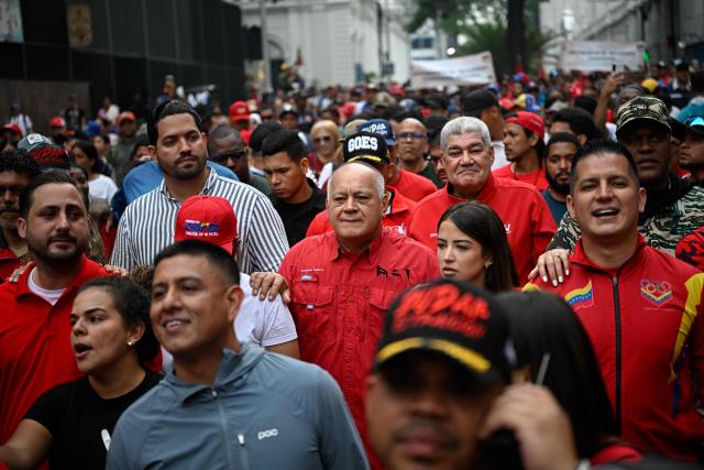 Venezuela's Interior, Justice and Peace Minister Diosdado Cabello (C) takes part in a march marking the 24th anniversary of late Venezuelan president Hugo Chavez's (1999-2013) return to power after a failed 2002 coup, in Caracas on April 13, 2026. (Photo by Federico PARRA / AFP)