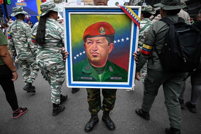A supporter of the Venezuelan government holds a portrait of late Venezuelan president Hugo Chavez (1999?2013) during a demonstration marking his return to power after a failed 2002 coup, in Caracas on April 13, 2026. (Photo by Federico PARRA / AFP)