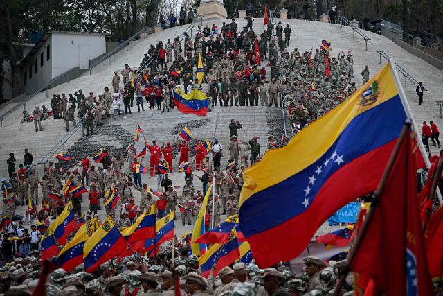 Members of the Bolivarian militia take part in a march marking the 24th anniversary of late Venezuelan president Hugo Chavez's (1999-2013) return to power after a failed 2002 coup, in Caracas on April 13, 2026. (Photo by Federico PARRA / AFP)