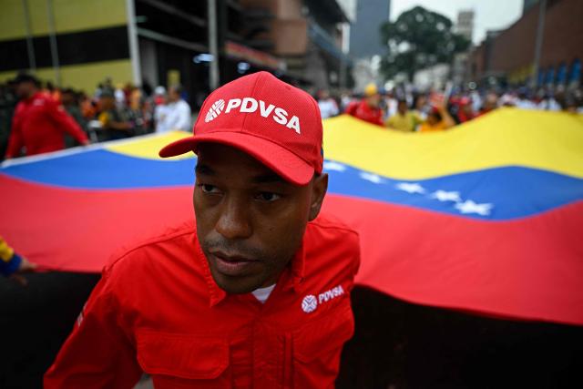 A supporter of the Venezuelan government marches during a demonstration marking the 24th anniversary of late Venezuelan president Hugo Chavez's (1999-2013) return to power after a failed 2002 coup, in Caracas on April 13, 2026. (Photo by Federico PARRA / AFP)