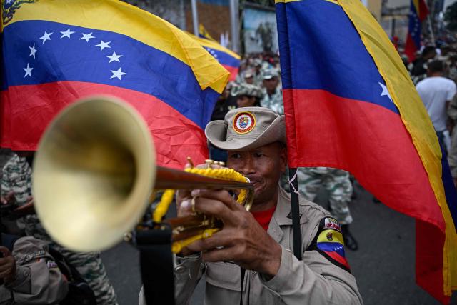 Members of the Bolivarian militia take part in a march marking the 24th anniversary of late Venezuelan president Hugo Chavez's (1999-2013) return to power after a failed 2002 coup, in Caracas on April 13, 2026. (Photo by Federico PARRA / AFP)
