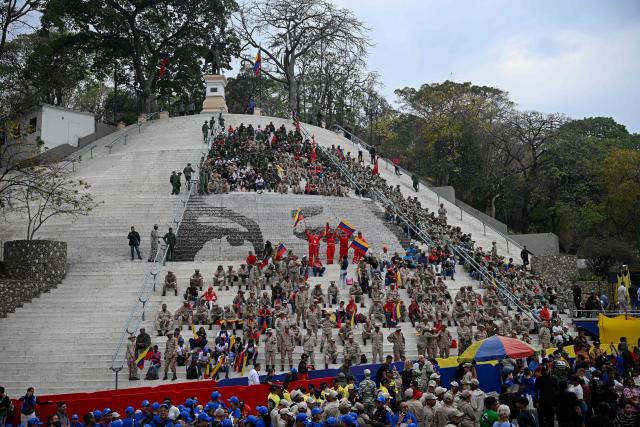 Members of the Bolivarian militia take part in a march marking the 24th anniversary of late Venezuelan president Hugo Chavez's (1999-2013) return to power after a failed 2002 coup, in Caracas on April 13, 2026. (Photo by Federico PARRA / AFP)