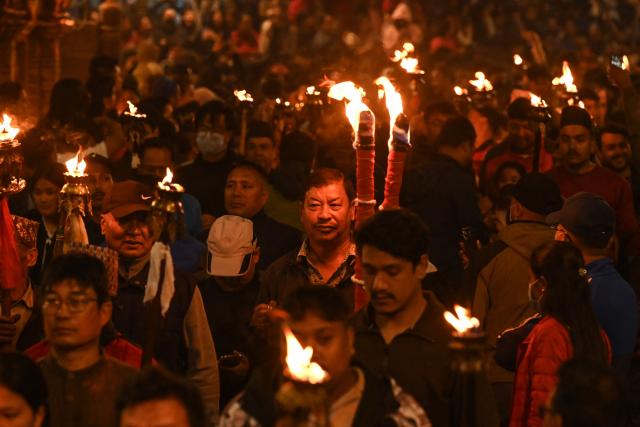 Hindu devotees carrying burning torches take part in a procession marking the Bisket Jatra festival to celebrate the Nepali New Year in Thimi on April 14, 2026. (Photo by PRAKASH MATHEMA / AFP)
