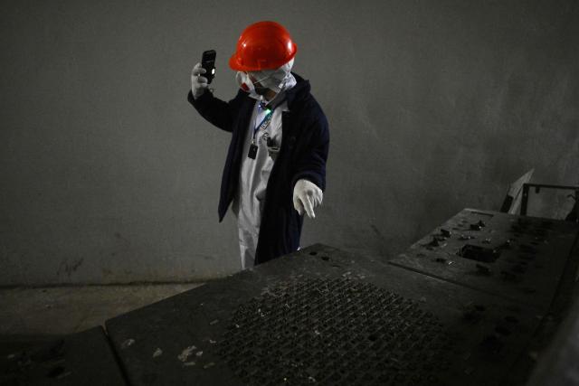 A visitor takes a selfie in the control room of the destroyed 4th block at the Chornobyl Nuclear Power Plant on April 9, 2026, amid the Russian invasion of Ukraine. An uncontrolled collapse of the internal radiation shell at the defunct Chernobyl nuclear power station in Ukraine could increase the risk of radioactivity release in the environment, Greenpeace warned on April 14, 2026. (Photo by Genya SAVILOV / AFP)