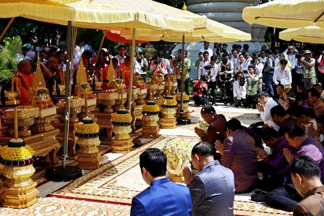 Cambodia's Deputy Prime Minister Hun Many (C) and government officials pray in front of Buddhist monks during Khmer New Year (Nokor Sankranta) celebrations at Wat Phnom in Phnom Penh on April 14, 2026. (Photo by TANG CHHIN Sothy / AFP)