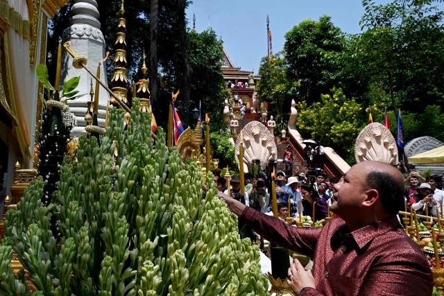 Cambodia's Deputy Prime Minister Hun Many (R) lights candles during Khmer New Year (Nokor Sankranta) celebrations at Wat Phnom in Phnom Penh on April 14, 2026. (Photo by TANG CHHIN Sothy / AFP)