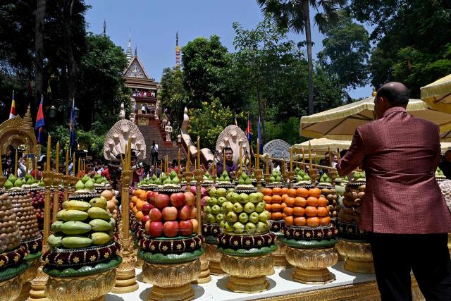Cambodia's Deputy Prime Minister Hun Many (R) and Phnom Penh governor Khuong Sreng (C) light candles during Khmer New Year (Nokor Sankranta) celebrations at Wat Phnom in Phnom Penh on April 14, 2026. (Photo by TANG CHHIN Sothy / AFP)