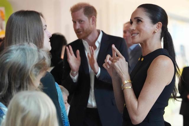 Britain's Prince Harry (C), Duke of Sussex, and his wife Meghan (R), the Duchess of Sussex, meet people at the Royal Children's Hospital in Melbourne on April 14, 2026. (Photo by Jonathan Brady / POOL / AFP)