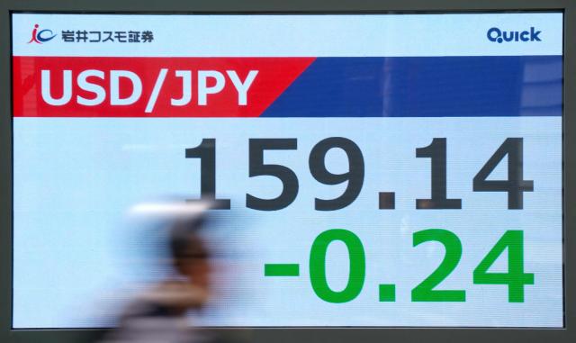 An electronic quotation board displays the foreign exchange rate of the Japanese yen against the US dollar along a street in Tokyo on April 14, 2026. (Photo by Kazuhiro NOGI / AFP)