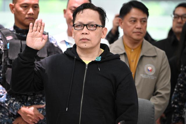 Ramil Madriaga (C) an alleged bagman of Philipine Vice-President Sara Duterte takes his oath as he attends the impeachment hearing of Vice-President Sara Duterte at the House of Representatives in Quezon City, suburban Manila on April 14, 2026. A Philippine congressional committee agreed overwhelmingly on March 4,to advance the impeachment case against Duterte, setting the stage for the poterntial vote that could decide her political future. (Photo by Ted ALJIBE / AFP)