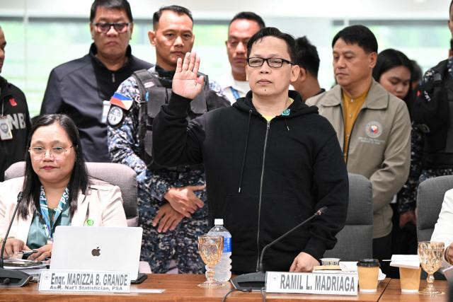 Ramil Madriaga (C) an alleged bagman of Philipine Vice-President Sara Duterte takes his oath as he attends the impeachment hearing of Vice-President Sara Duterte at the House of Representatives in Quezon City, suburban Manila on April 14, 2026. A Philippine congressional committee agreed overwhelmingly on March 4,to advance the impeachment case against Duterte, setting the stage for the poterntial vote that could decide her political future. (Photo by Ted ALJIBE / AFP)