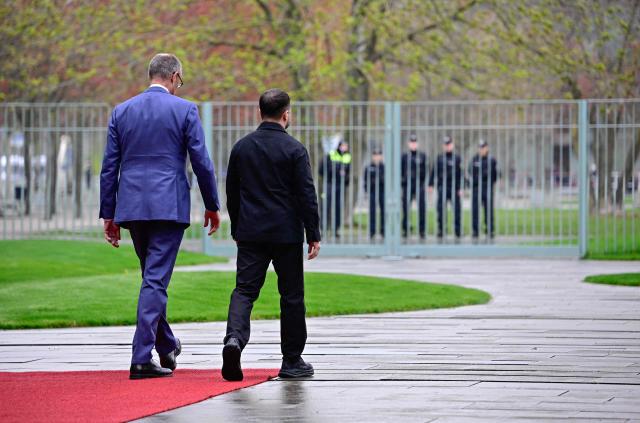 German Chancellor Friedrich Merz and Ukrainian President Volodymyr Zelensky walk during a welcoming ceremony in the courtyard of the Chancellery in Berlin on April 14, 2026 prior to German-Ukrainian government consultations. The meeting comes as US-initiated peace talks between Russia and Ukraine have stalled, with Kyiv baulking at the idea it could cede territory to Russia. (Photo by Tobias SCHWARZ / AFP)