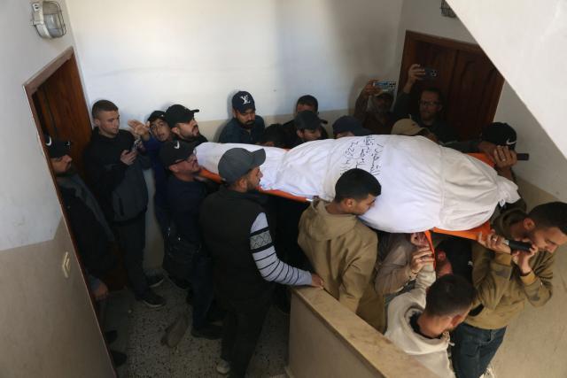 Palestinian mourners carry the shrouded body of Islam Quneita, a writer and managing editor for the website “Palestine Now,” who, according to medics, was killed in an Israeli strike the day before, during his funeral in Gaza City on April 14, 2026. Gaza is still reeling from more than two years of war between Israel and Hamas, sparked by the militant group's October 7, 2023, attack on Israel. (Photo by Omar AL-QATTAA / AFP)