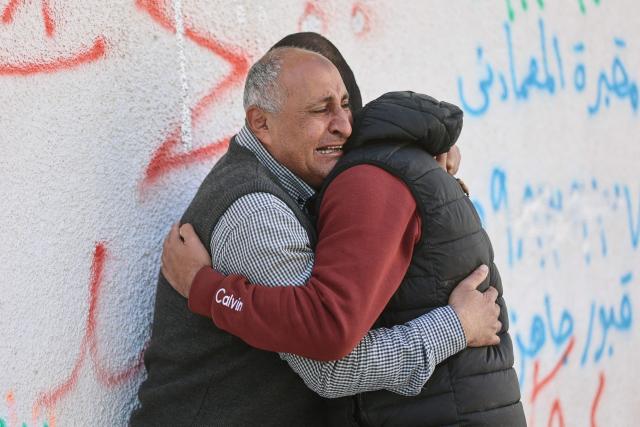 Two Palestinian men grieve during the funeral of Islam Quneita, a writer and managing editor for the website “Palestine Now,” who, according to medics, was killed in an Israeli strike the day before, in Gaza City on April 14, 2026. Gaza is still reeling from more than two years of war between Israel and Hamas, sparked by the militant group's October 7, 2023, attack on Israel. (Photo by Omar AL-QATTAA / AFP)