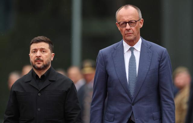 German Chancellor Friedrich Merz (R) and Ukrainian President Volodymyr Zelensky review a military honor guard during a welcome ceremony at the Chancellery in Berlin on April 14, 2026 prior to German-Ukrainian government consultations. The meeting comes as US-initiated peace talks between Russia and Ukraine have stalled, with Kyiv baulking at the idea it could cede territory to Russia. (Photo by Odd ANDERSEN / AFP)