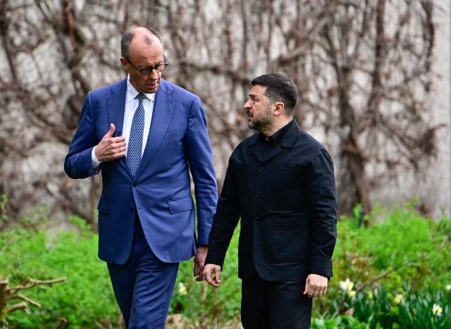 German Chancellor Friedrich Merz and Ukrainian President Volodymyr Zelensky talk as they walk in the garden in the backyard of the Chancellery in Berlin on April 14, 2026 prior to German-Ukrainian government consultations. The meeting comes as US-initiated peace talks between Russia and Ukraine have stalled, with Kyiv baulking at the idea it could cede territory to Russia. (Photo by Tobias SCHWARZ / AFP)
